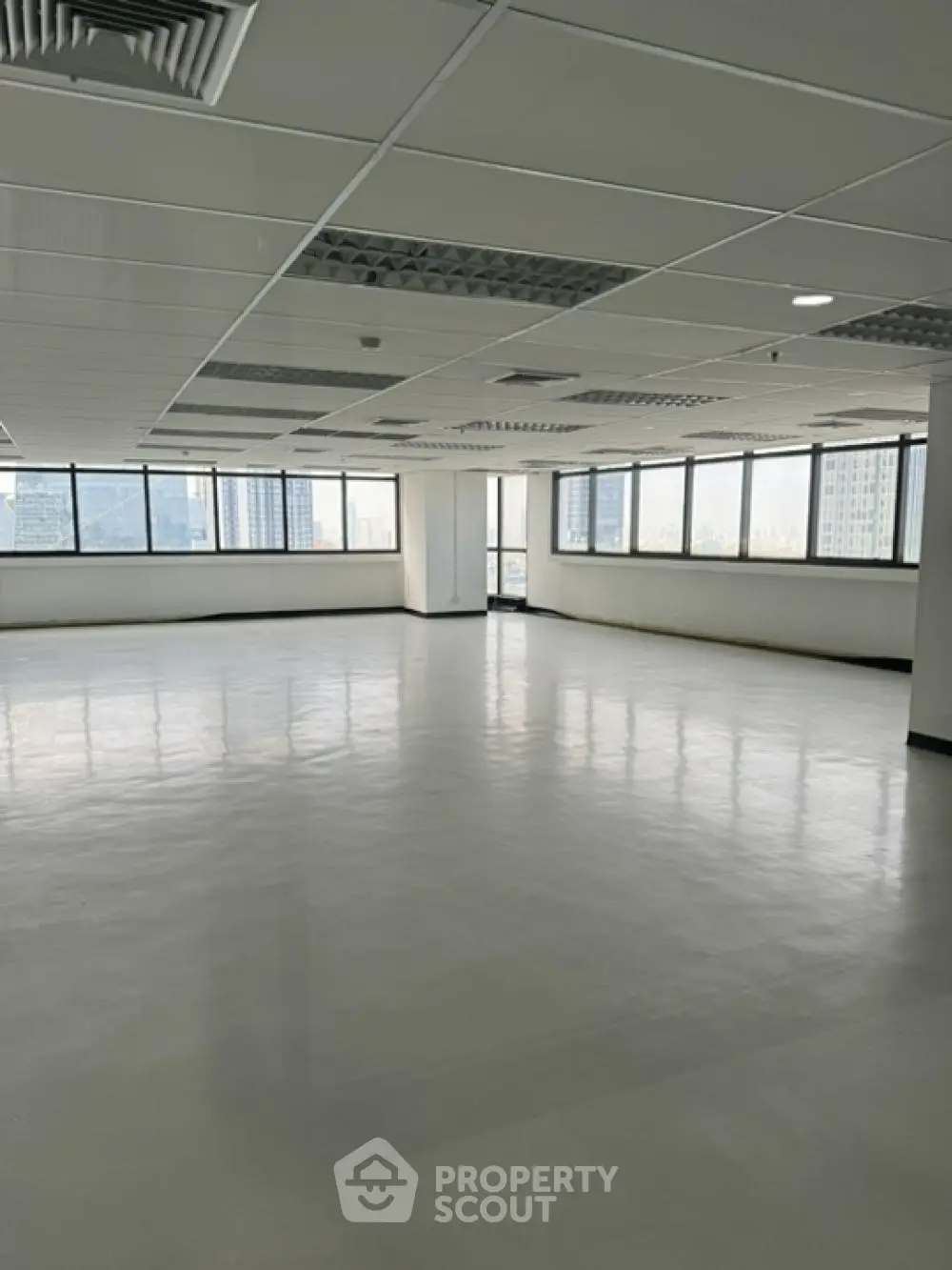 Expansive open-plan office space with abundant natural light from wrap-around windows, ready for a custom layout in a prime location.