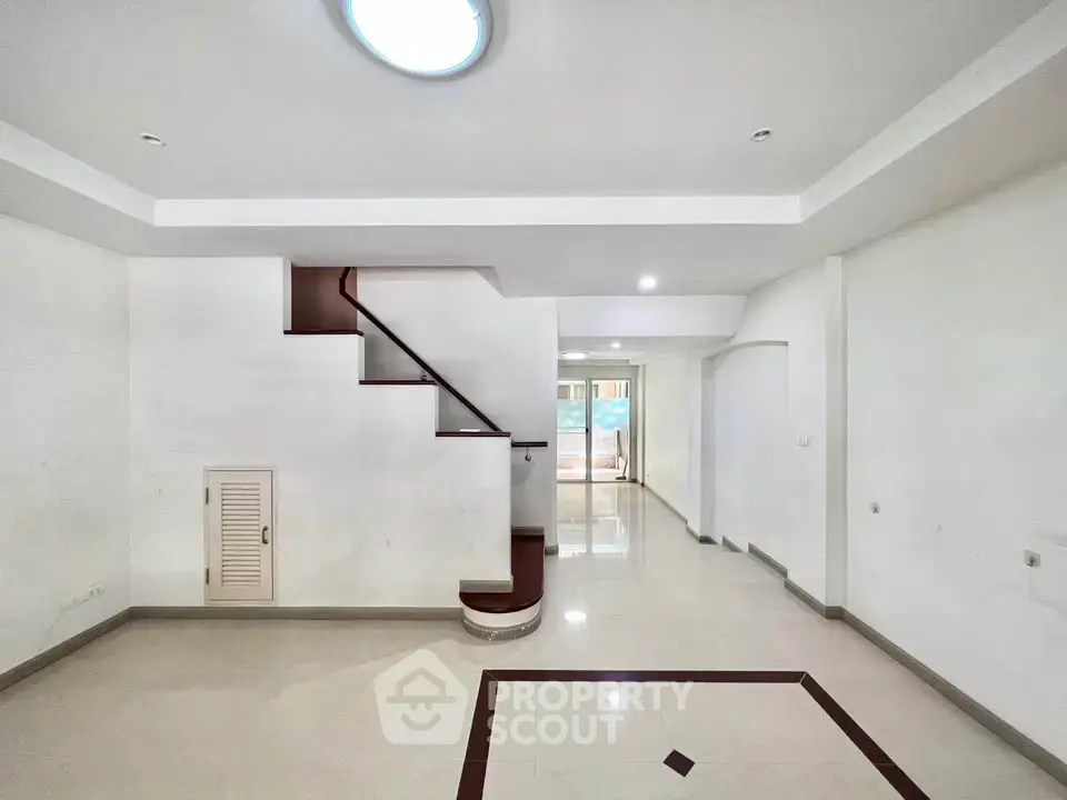 Spacious modern interior with elegant staircase and polished floors, ideal for stylish living.
