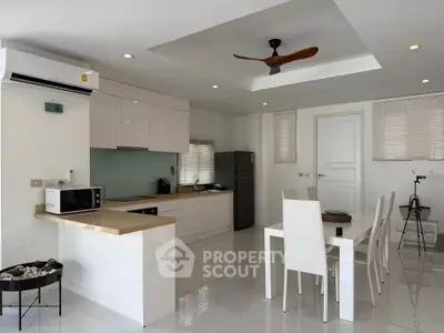 Modern kitchen and dining area with sleek white cabinetry and contemporary decor.