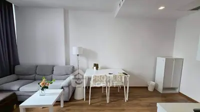 Modern living room with cozy gray sofa, white furniture, and wooden flooring.