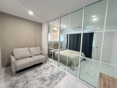 Modern bedroom with mirrored closet and cozy seating area