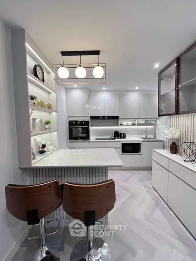 Modern kitchen with sleek design, featuring an open layout and stylish bar seating.