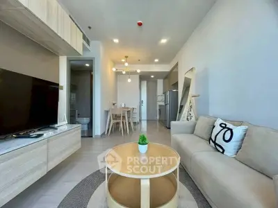 Modern living room with open kitchen, stylish decor, and cozy seating area in a contemporary apartment.