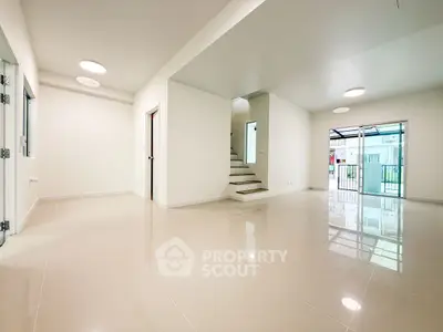 Spacious modern living room with glossy tiled floors and natural light