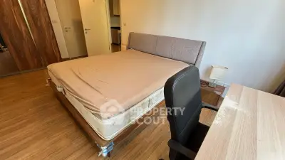 Spacious bedroom with wooden flooring and modern furniture