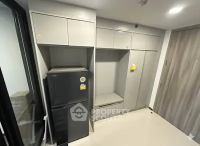 Modern kitchen with sleek cabinetry and a compact refrigerator