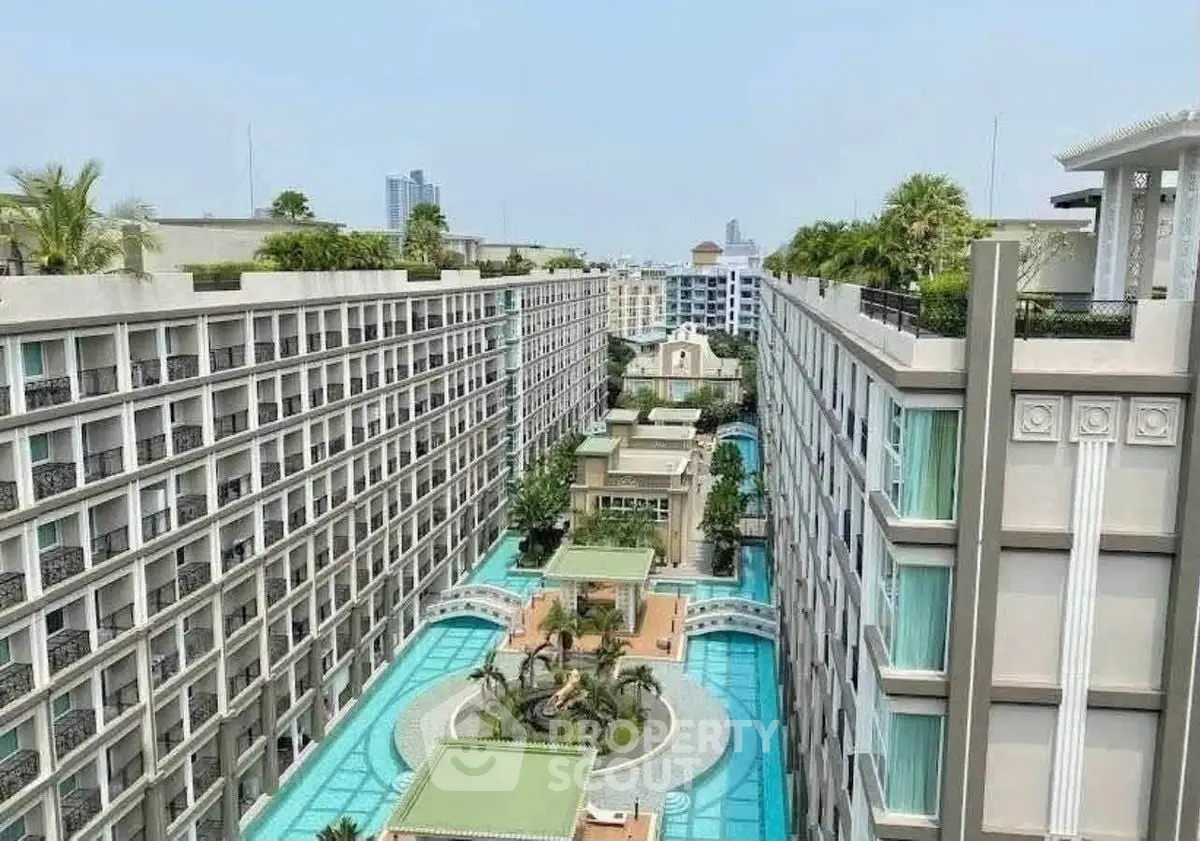 Luxurious apartment complex with stunning pool and lush greenery in prime urban location.