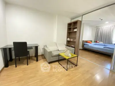 Modern studio apartment with cozy living area and bedroom, featuring wooden flooring and ample natural light.
