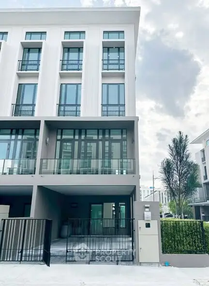 Modern multi-story building with sleek design and spacious balconies.