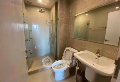 Modern bathroom with glass shower and sleek fixtures in a contemporary apartment.