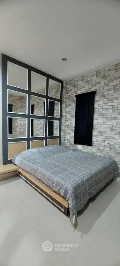 Modern bedroom with stylish mirrored wall and cozy bed in contemporary apartment.