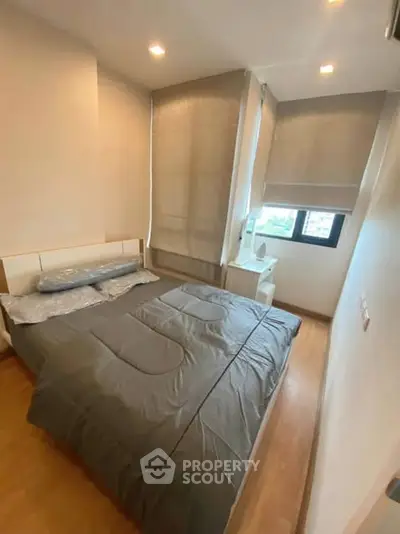 Cozy bedroom with modern decor and ample natural light, perfect for relaxation.