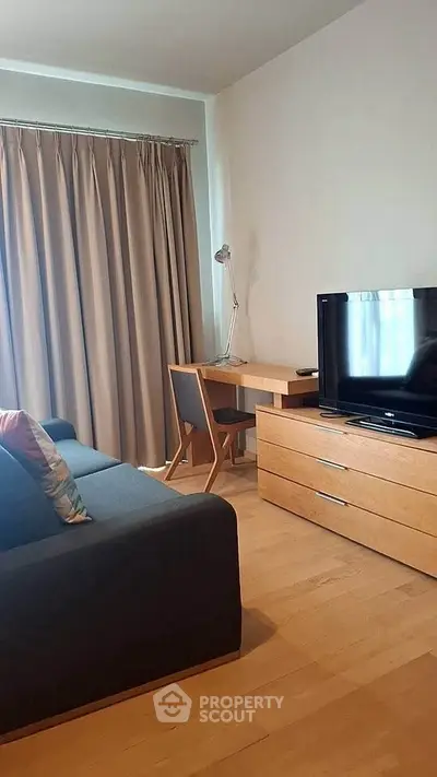 Modern living room with sleek furniture and natural light, featuring a cozy sofa and a stylish desk area.