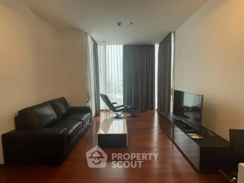 Spacious modern living room with sleek furniture and large windows offering natural light.