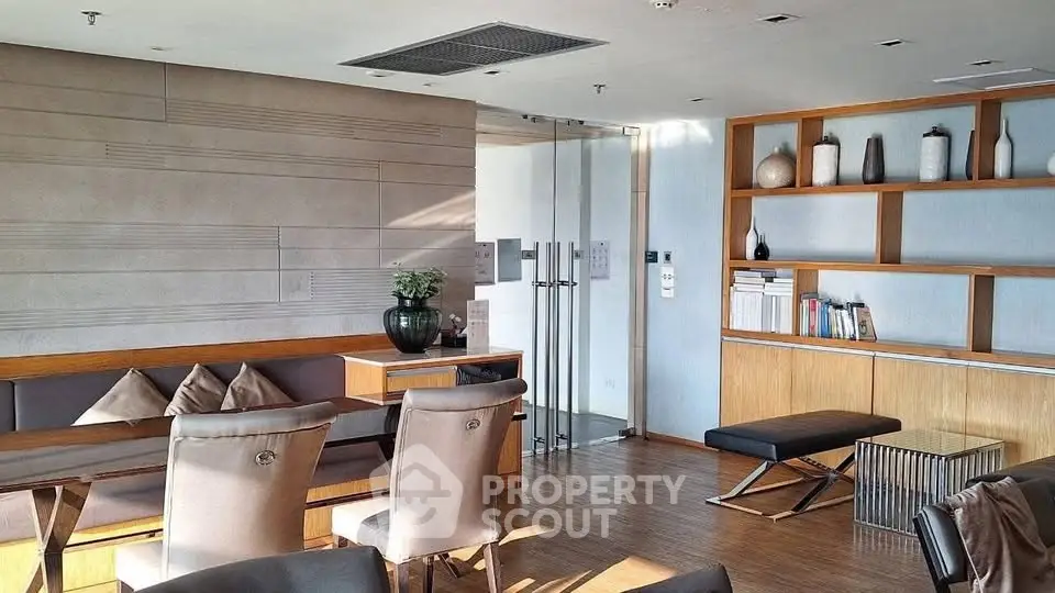 Modern living room with stylish furniture and built-in shelving, featuring natural light and elegant decor.