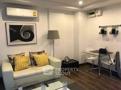 Cozy living room with modern decor and dining area, featuring a stylish sofa and elegant lighting.