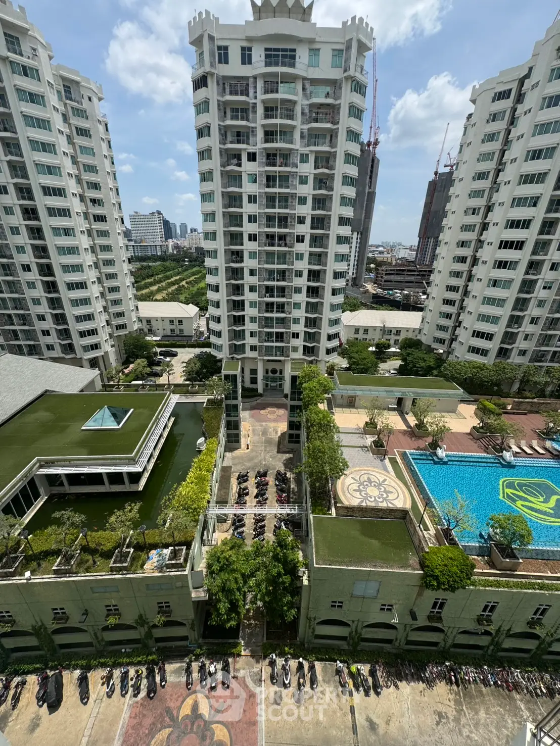Stunning aerial view of modern residential complex with pool and lush greenery, ideal urban living.