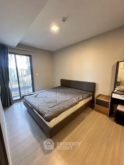 Spacious bedroom with modern decor and balcony access in a stylish apartment.