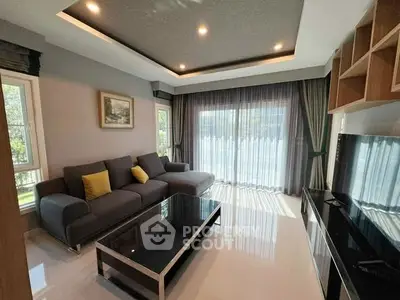 Modern living room with sleek furniture and large windows for natural light.