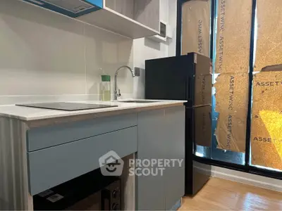 Modern kitchen with sleek cabinetry and compact appliances in a contemporary apartment.