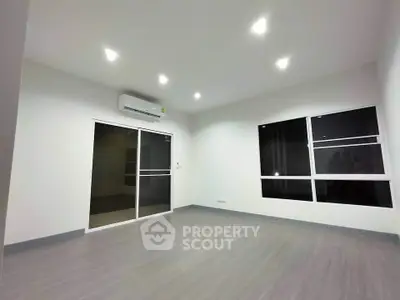 Spacious modern living room with sleek flooring and large windows for natural light.