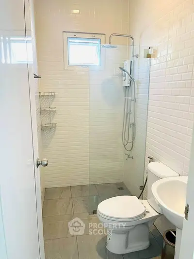 Modern bathroom with sleek shower and white tiles, compact yet stylish design.