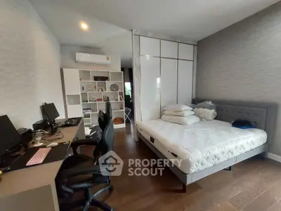 Spacious bedroom with modern decor and study area, featuring a comfortable bed and ample storage.