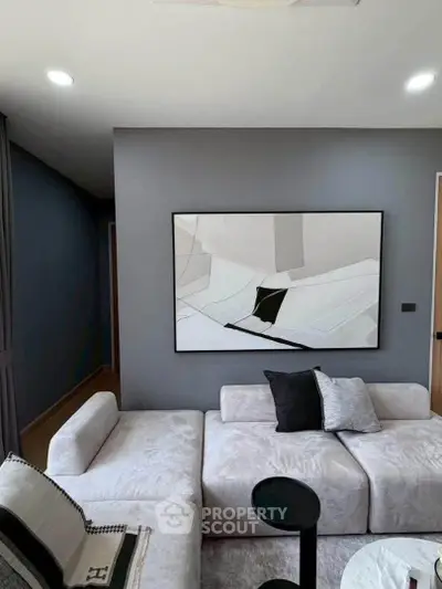 Modern living room with stylish abstract art and plush white sofa, perfect for contemporary urban living.