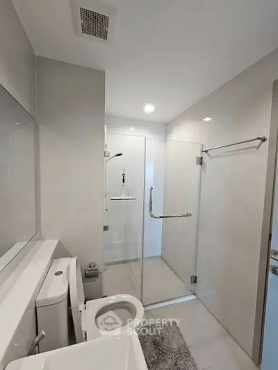 Modern bathroom with glass shower enclosure and sleek fixtures