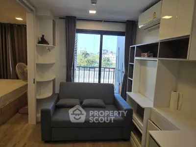 Modern living room with balcony view and stylish furniture in a cozy apartment.