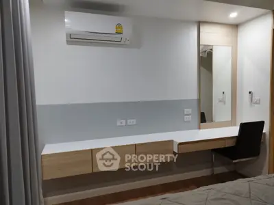 Modern bedroom with sleek desk, mirror, and air conditioning unit