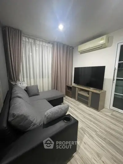 Modern living room with sleek furniture and large TV, perfect for relaxation and entertainment.