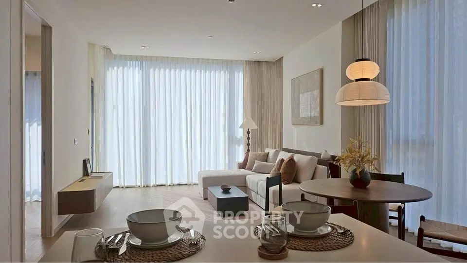 Elegant living room with modern decor and natural light, featuring a cozy seating area and dining space.