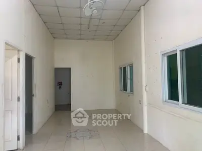 Spacious empty room with tiled floor and ceiling fan, ready for customization.