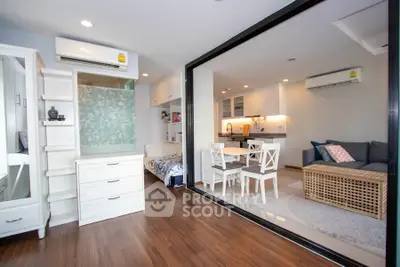 Modern open-plan living room with kitchen, featuring stylish furniture and wooden flooring.
