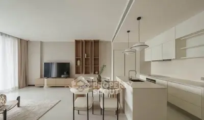 Modern open-plan living room and kitchen with sleek design and neutral tones.