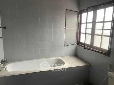Spacious bathroom with bathtub and natural light from large window