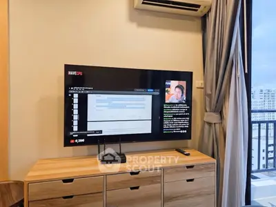 Modern living room with wall-mounted TV and balcony view in urban apartment.