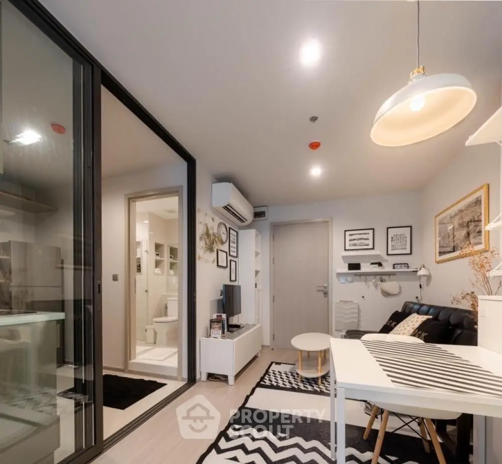Modern living room with stylish decor and open layout, featuring a cozy seating area and contemporary lighting.