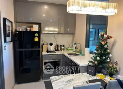 Modern kitchen with sleek cabinetry, marble countertop, and festive decor in a cozy apartment setting.
