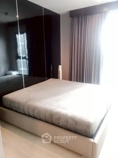 Modern bedroom with large mirrored wardrobe and soft lighting