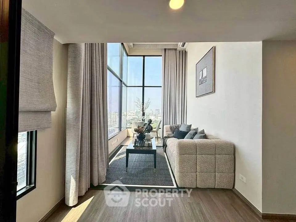 Spacious modern living room with floor-to-ceiling windows and stunning city view.