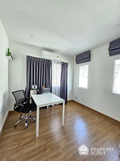 Modern study room with sleek desk and ergonomic chair, featuring natural light and stylish curtains.