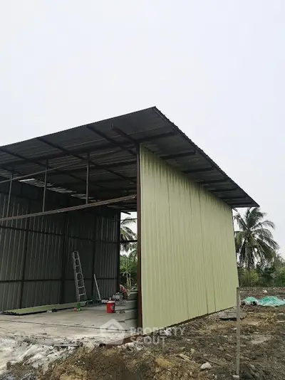 Modern industrial-style building under construction with metal siding and open framework.