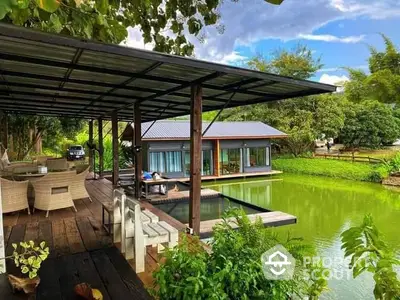 Charming lakeside home with a spacious deck, surrounded by lush greenery and serene water views.