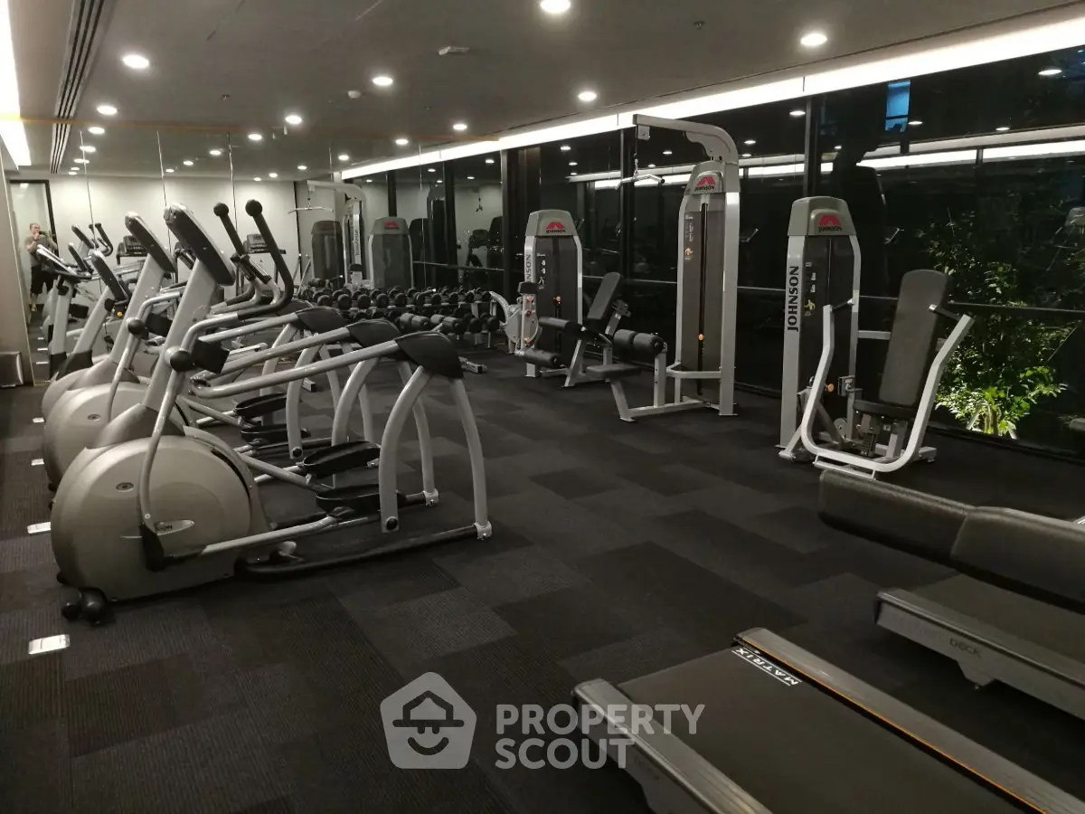 Modern gym with state-of-the-art fitness equipment and large windows for natural light.