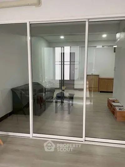 Modern living room with glass partition and sleek furniture design
