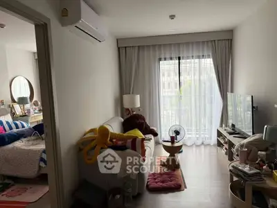 Cozy living room with modern decor and natural light, adjacent to a stylish bedroom.