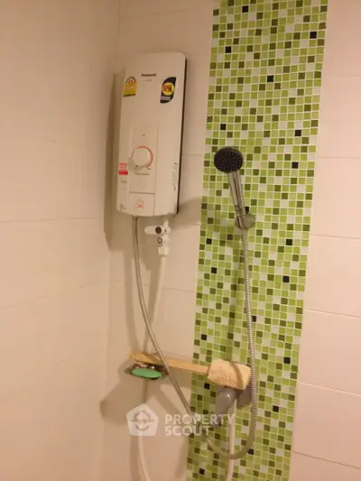 Modern bathroom with stylish shower and green mosaic tiles