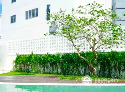 Luxurious poolside view with lush greenery and modern architecture